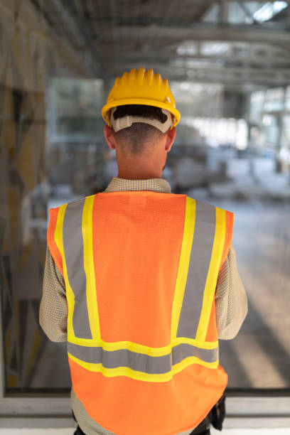 istock Back shot of Construction engineer examining building blueprint at construction site 1352454940