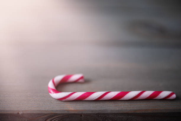 istock Candy cane in the sunshine on wooden background. 1352457096