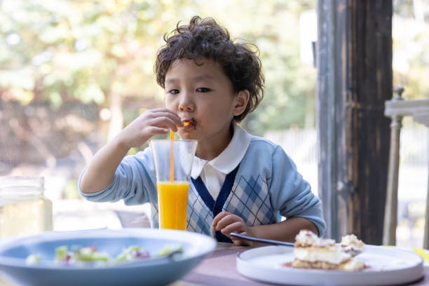 istock A little boy eating in a restaurant 1352457528