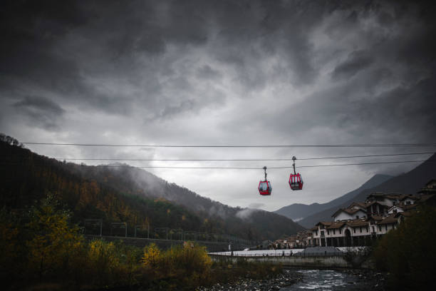istock Cable Car across the river against mountains and stormy clouds 1352460012