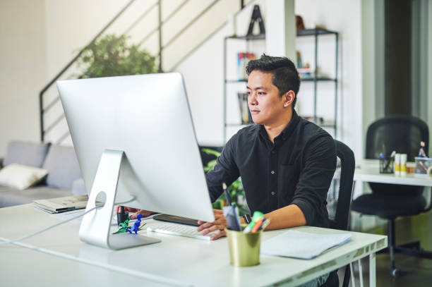 istock Shot of a young businessman working at his desk and using his computer 1352461060