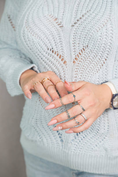 istock Women's hands with a beautiful manicure and rings are folded on the chest 1352462251