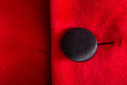 Red stylish jacket with buttons, background. Stylish clothes, macro, elegant prestige