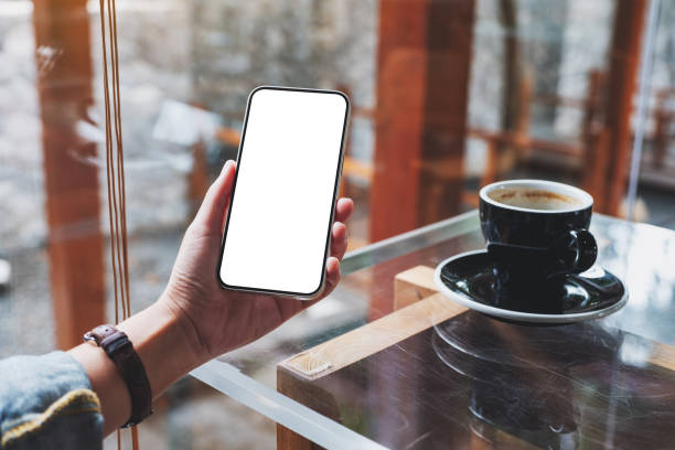 istock a woman holding mobile phone with blank white screen in cafe 1352463246