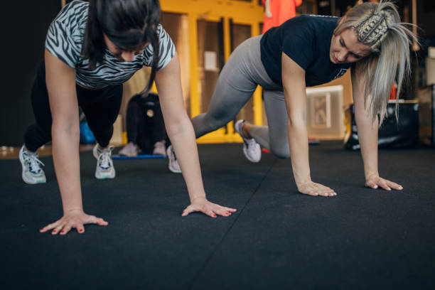istock Personal trainer showing a woman push-ups 1352464084