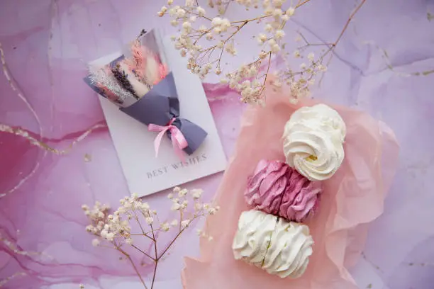 Delicate pink and white marshmallow with decoration of gypsophila and dryflowers bouquet. Cozy winter weekends. Girly background. Homemade sweets. High quality photo