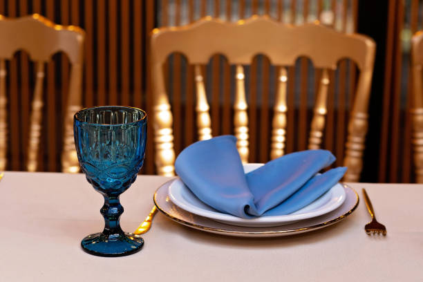 istock Festive wedding, table setting with blue linen napkins, candles. Wedding decorations. Restaurant menu concept. Soft selective focus. 1352464767