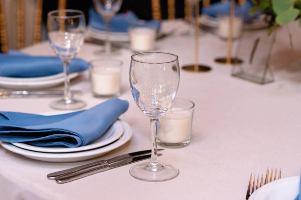 istock Festive wedding, table setting with blue linen napkins, candles. Wedding decorations. Restaurant menu concept. Soft selective focus. 1352464768