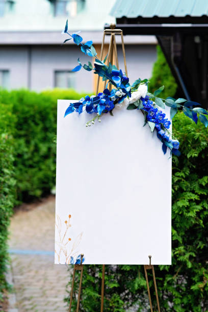 Wedding board, mockup, invitation easel, with space for an inscription, decorated with fresh flowers. Festive decor, copy space. Soft selective focus.