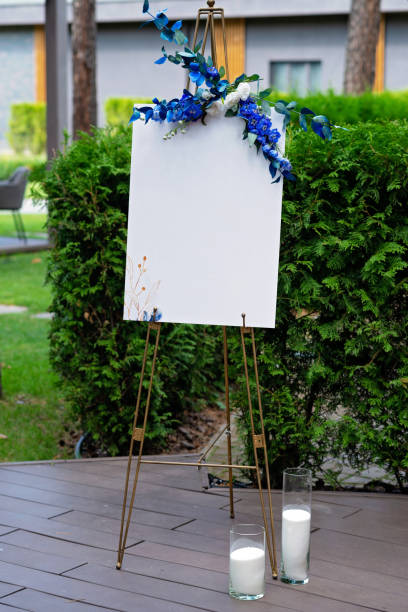 istock Wedding board, mockup, invitation easel, with space for an inscription, decorated with fresh flowers. Festive decor, copy space. Soft selective focus. 1352464941