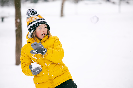 Cute little boy playing in the snow. Snowball fight.