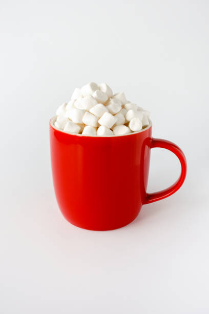 istock Red Mug filled with Mini Marshmallows isolated on White 1352467578
