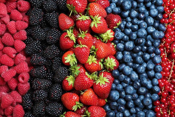 istock Mix of different ripe tasty berries as background, top view 1352468372