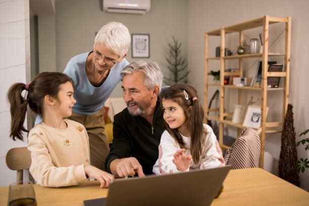 istock Two sisters and their grandparents using laptop and having fun 1352469388