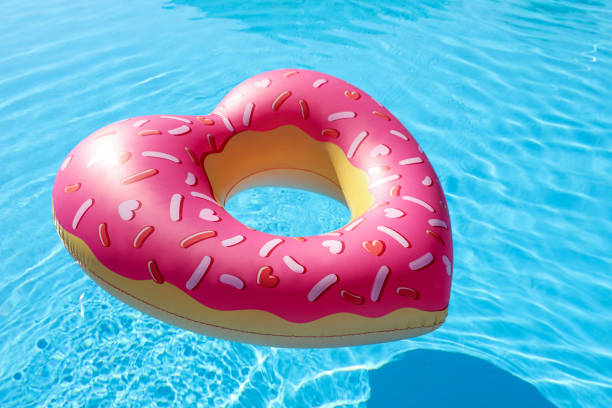 istock Heart shaped inflatable ring floating in swimming pool. Summer vacation 1352470698