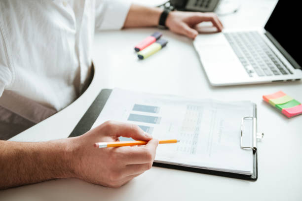 istock Cropped image of man writing something by the table 1352470748
