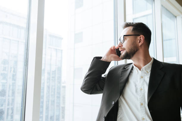 istock Bearded business man talking on phone and looking away 1352471019