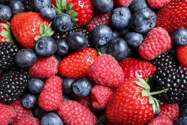 istock Mix of different ripe tasty berries as background, top view 1352471656
