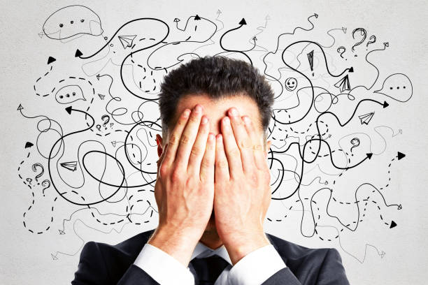 矢印と思考アイコンスケッチでコンクリートの壁の背景に目を覆う魅力的な若いヨーロッパのビジネスマンの肖像画。ソリューション、方向性、成功、ブレーンストーミングの概念。 - 分かんない 難しい ストックフォトと画像