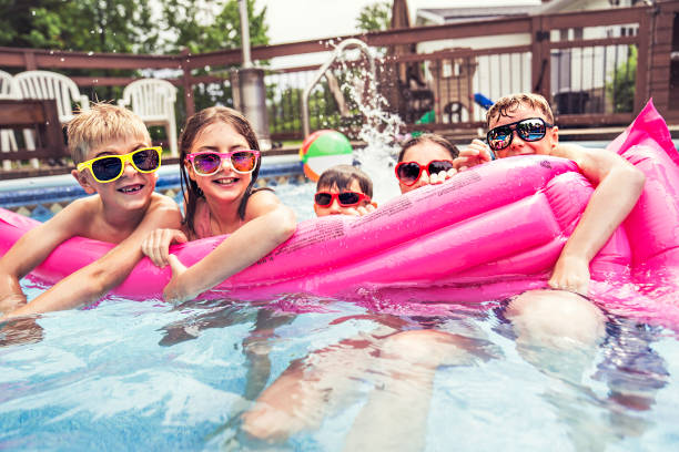 istock group of children having fun in Pool on the summer time 1352481470