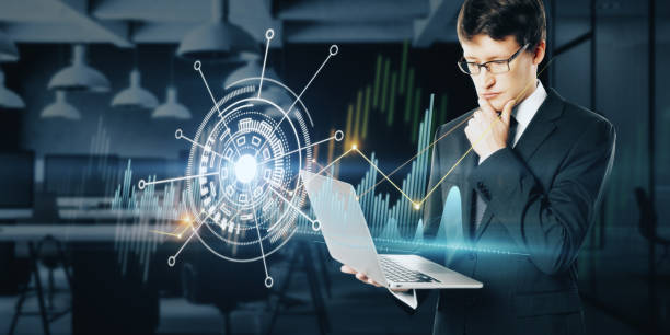 istock Attractive young european businessman using creative business chart hologram on blurry office interior background. Innovation, finance, trade, future, ai and technology concept. Double exposure. 1352482204