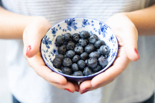 istock holding a bowl of blueberries 1352482390