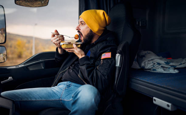 il camionista mangia in cabina - food motivation driving drive foto e immagini stock