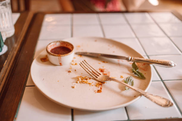 istock Empty dirty dish after breakfast with sauce and dessert fork. White trendy modern dirty plate on wood cement background 1352487147