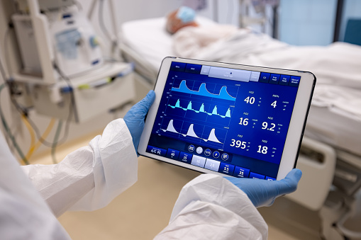 Close-up on a doctor checking the vital signs of a patient hospitalized for COVID-19 - healthcare and medicine concepts. **DESIGN ON SCREEN BELONGS TO US**