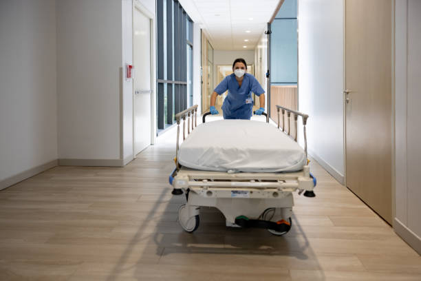 Doctors and nurse wheeling patient on stretcher in hospital's corridor.