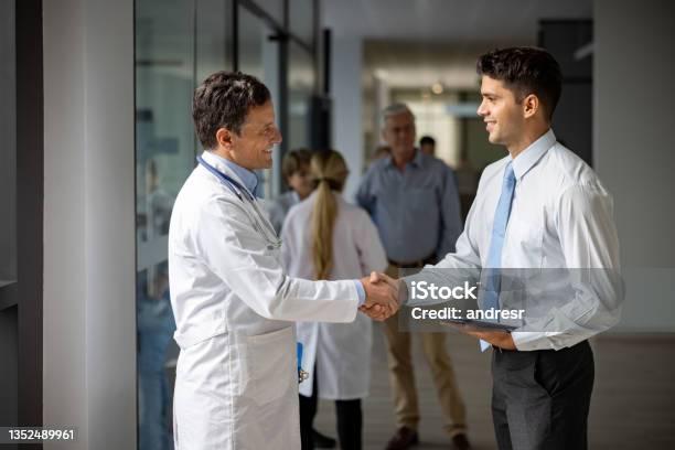 Medical Sales Representative Greeting A Doctor With A Handshake At The Hospital Stock Photo - Download Image Now