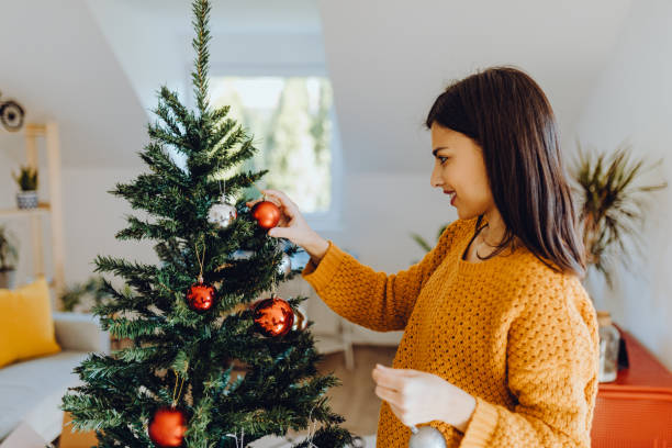 istock young women decorating her home for christmas 1352489970