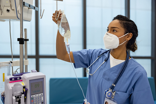 Enfermera del hospital que pone un goteo intravenoso a un paciente photo