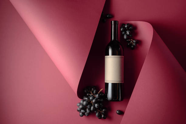 bouteille de vin rouge et raisins bleus. - merlot cabernet photos et images de collection