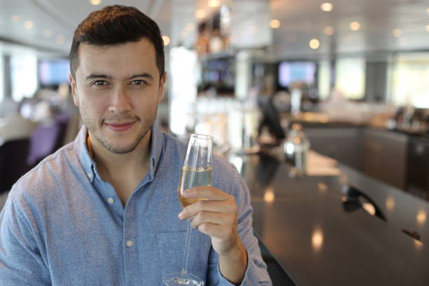 hübscher junger mann trinkt champagner an der bar - flute solo stock-fotos und bilder