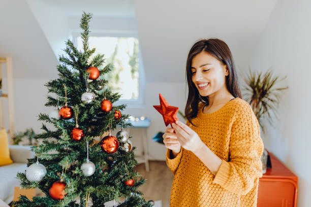 istock young women decorating her home for christmas 1352491028