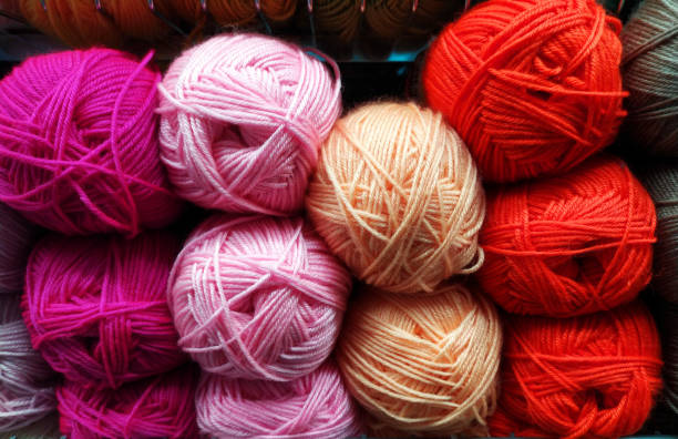 istock Knitted pattern of multi-colored wool yarn on the shop window. Background for knitting. Knitting yarn for handmade winter clothes. Colorful background with a ball of yarn. 1352491116