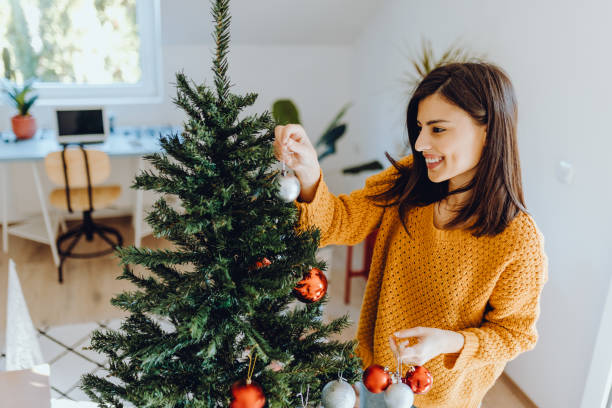 istock young women decorating her home for christmas 1352491126