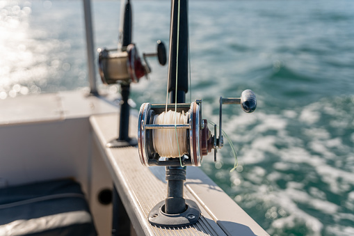 Two big fishing reels on a boat in the ocean. These reels are used to catch big game fish such as Mahi-mahi, dorado, tuna, sailfish, swordfish sharks and marlin. They are used in tropical and cold water oceans.