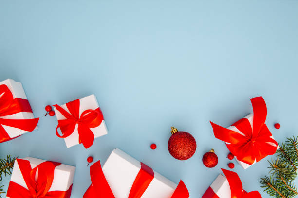 istock Christmas composition, gifts, fir tree branches, red decorations on blue background, winter, new year concept, flat lay, copy space 1352494848
