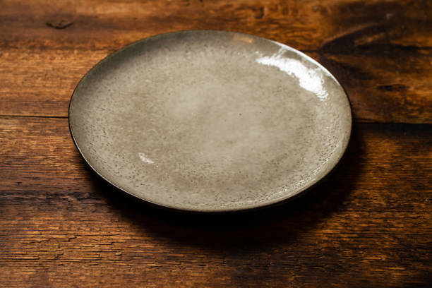 istock empty clay plate on dark wooden background 1352495009