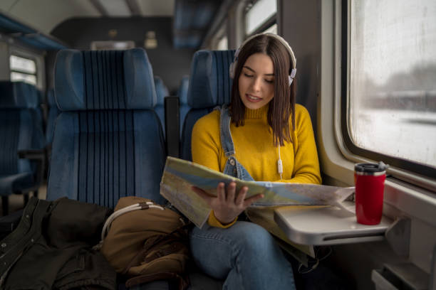 istock Young woman in train is reading a map 1352495303