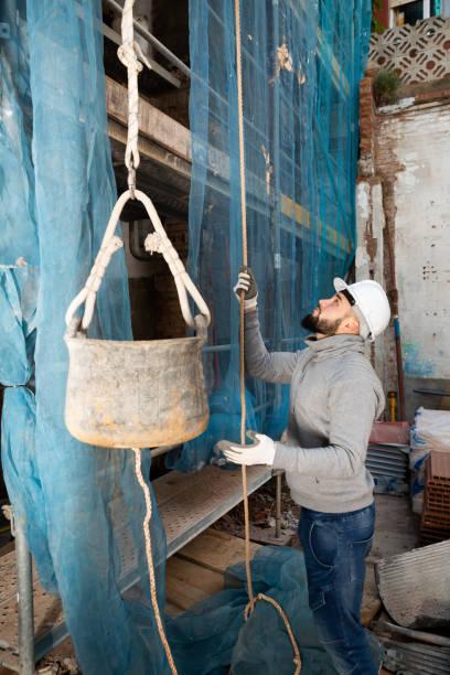 istock Worker lifting bucket with cement mortar 1352497308