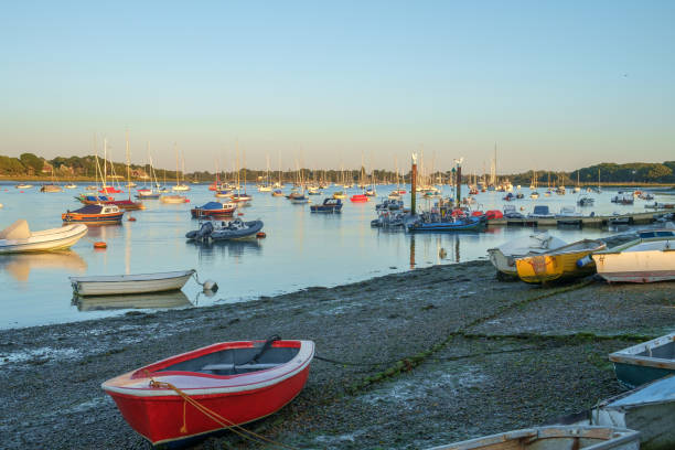 Ichenor Waterfront, Chichester Harbour, UK Various nautical vessels ranging from small rowing boats to larger yachts are seen in this view of Chichester Harbour in the late evening sun at low tide. chichester stock pictures, royalty-free photos & images