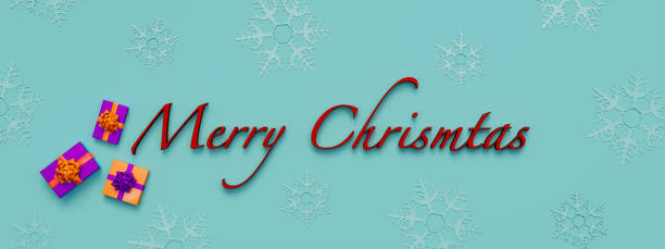 istock Merry Christmas written in red letters against a blue background with slightly visible light blue snowflakes. Some colored gift boxes next to the word. 1352499843