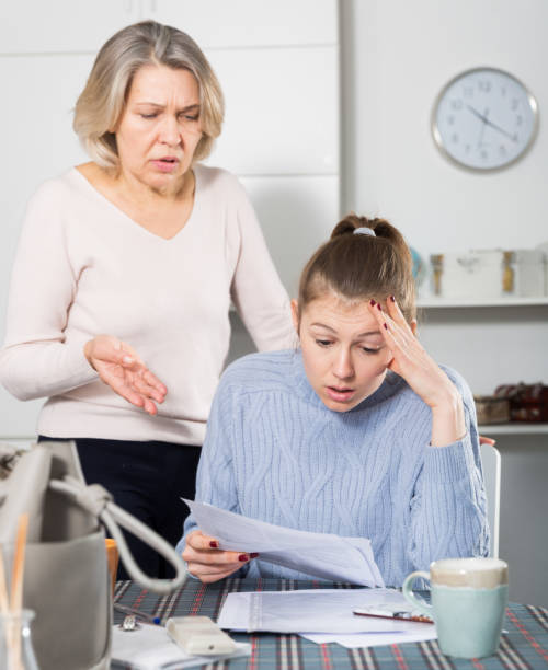 istock Sad young female and mother with financial documents 1352499961