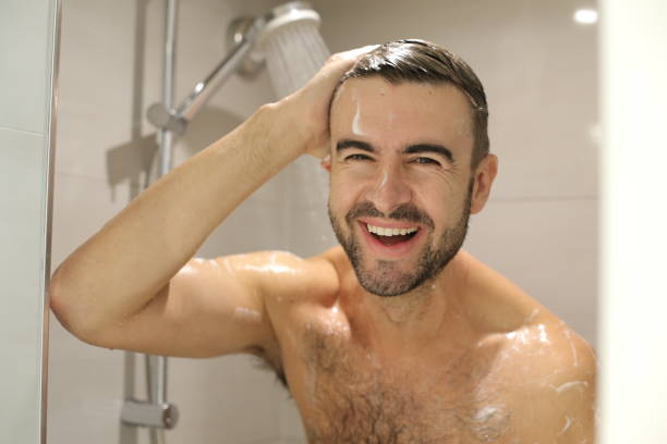 istock Handsome man smiling in the shower 1352500420