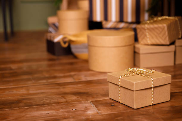 istock christmas gift in cardboard box on wooden floor 1352501423