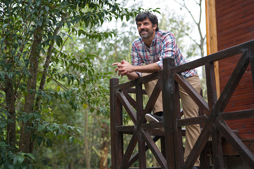 Portrait of a happy man enjoying nature outside a wilderness resort cabinn