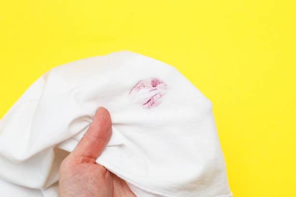 woman holding a white shirt with red kiss lipstick on a yellow background - proof of love imagens e fotografias de stock